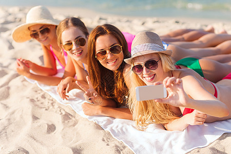 暑假,旅游,技术人的群微笑的女人戴着太阳镜帽子,海滩上用智能手机自拍图片