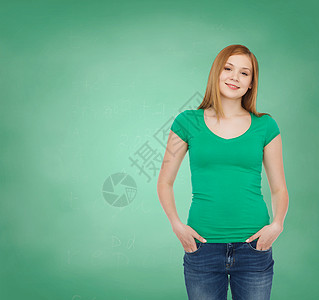 教育,学校,广告人的微笑的十几岁女孩穿着休闲服装绿板背景图片