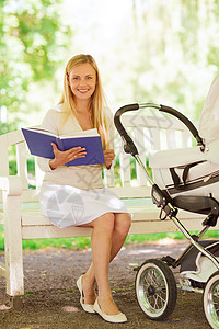 家庭,孩子,休闲,教育父母的快乐的母亲与婴儿车阅读书籍公园图片