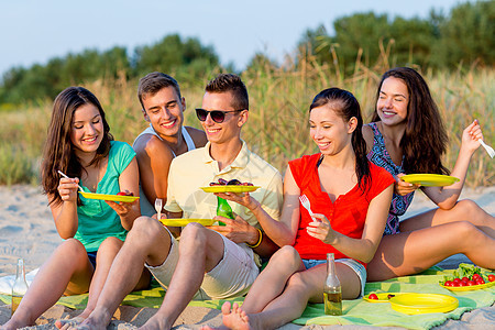 友谊,幸福,暑假,假期人们的群微笑的朋友坐海滩上图片