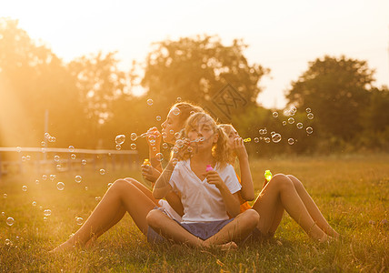 三个十几岁的女孩公园玩得很开心两个朋友户外夏天的人泡泡图片