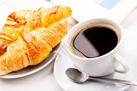 早餐加杯黑咖啡牛角包报纸背景图片
