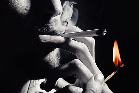 男人的手用火柴特写点燃支香烟图片