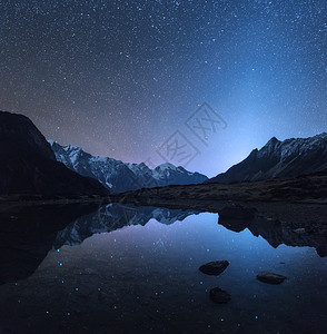 尼泊尔的星空之夜神奇的夜景与山湖景观与高岩石与雪峰天空与星星反射水尼泊尔喜马拉雅山旅行太空背景图片