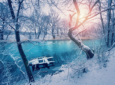 日落时河上的冬季森林五颜六色的风景与雪树,河流与倒影寒冷的夜晚雪覆盖着树木湖泊太阳蓝天雪冬里美丽的森林日图片