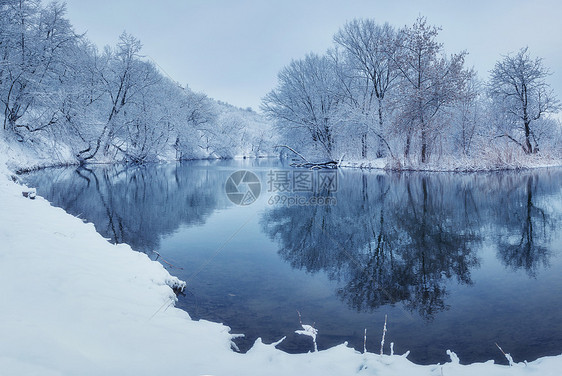 日落时河上的冬季森林五颜六色的风景与雪树,河流与倒影寒冷的夜晚雪覆盖着树木湖泊太阳蓝天雪冬里美丽的森林冬图片