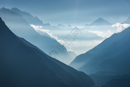 尼泊尔日落时群山低云轮廓的雄伟景色喜马拉雅山的高岩石,美丽的蓝天阳光神奇的喜马拉雅山自然背景日落时群山低云图片