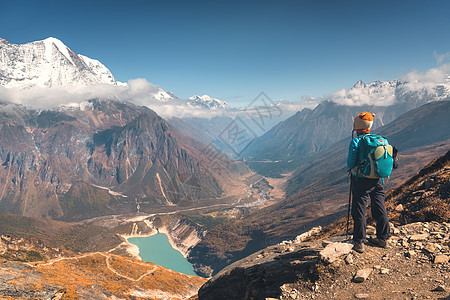 站山顶上的轻女人,日落时看着美丽的山谷,湖泊岩石小山风景与女孩,岩石云,蓝天尼泊尔旅行冒险站山图片
