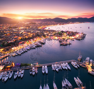 日落时鸟瞰船只美丽的建筑鸟瞰船只美丽的城市日尔马里斯,土耳其惊人的景观与船码头湾,海洋,城市灯,山,天空,云图片