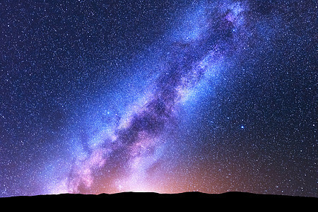 银河系风景优美的夜晚景观,明亮的银河,天空充满了星星,橙色的光山丘闪亮的星星与宇宙的美丽景象星空的图片