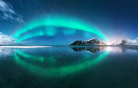 极光挪威洛福滕岛的北极光充满极地灯光的星空夜间冬季景观与极光,海洋与天空反射,海滩,山脉,城市灯光绿色北极光图片