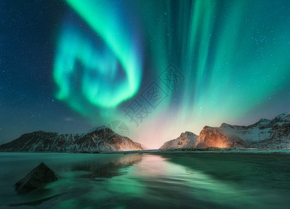 挪威洛芬岛的北极光极光绿色的北极光极地灯光的星空夜间冬季景观与极光,海洋与天空反射,石头,海滩雪山背景图片