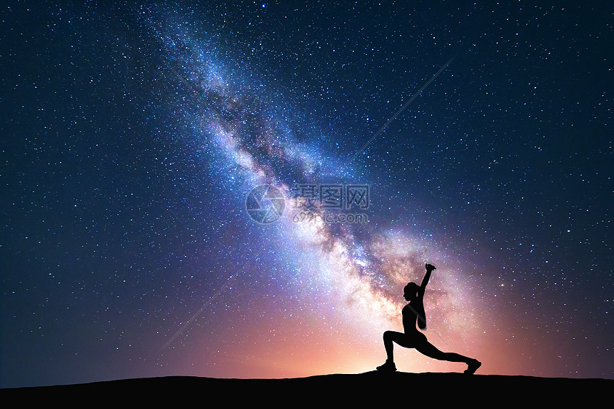 银河与个站立的女人田野上练瑜伽的轮廓美丽的风景与冥想的女孩夜空与