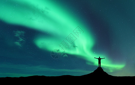 极光轮廓站立的人举手臂挪威的山上北极光快乐的人星空,绿色的极地灯夜风景北极光旅行旅游图片