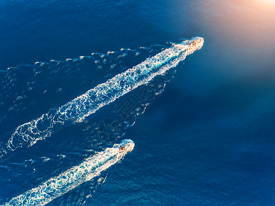 游艇海上日落时豪华浮船的鸟瞰图五颜六色的景观与船码头湾,蓝海游艇的无人驾驶飞机上俯瞰豪华游轮带摩托艇的背景图片