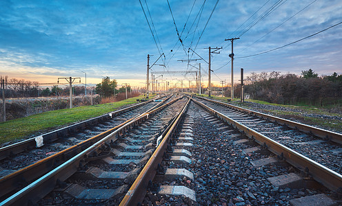日落时的铁路火车站抗蓝天工业景观与铁路,多云的天空,绿草,树木铁路枢纽重工业货物运输货运运铁路图片