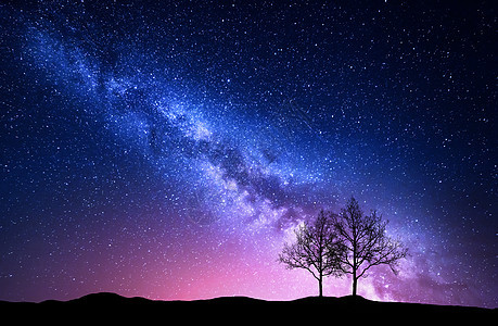 星空,粉红色的银河树木夜风景星星的天空粉红色的银河夜风景与独自的树木山上抗五颜六色的银河神奇的星图片