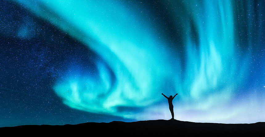 挪威的山上,北极光站立的女人的轮廓举了手臂北极光快乐的女孩星空,绿色的极地灯夜风景旅行背景图片