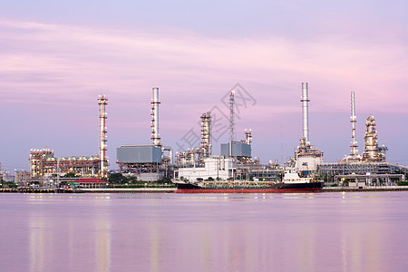 黄昏时沿河炼油厂油轮的景观图片