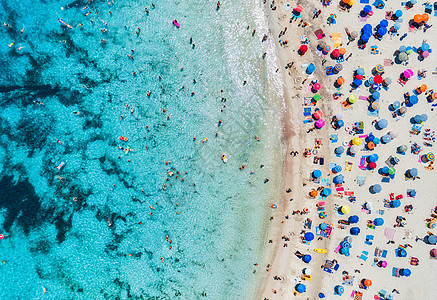 空中观看沙滩与彩色雨伞,游泳的人海湾与透明的蓝色水阳光明媚的日子夏天西牙巴利阿里群岛马略卡岛旅行的风景图片
