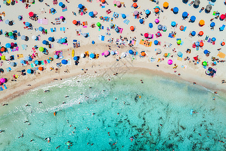 牙列拥挤阳光明媚的早晨,用五颜六色的雨伞俯瞰沙滩,用透明的蓝色水海湾游泳西牙巴利阿里群岛马略卡岛旅行的风景景观背景