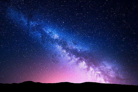 银河粉红色的光山上夜晚五彩缤纷的风景夏天小山的星空美丽的宇宙带星系的背景旅行背景背景图片