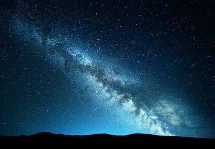 夜间景观与惊人的银河山上蓝色的夜晚星空,夏天小山美丽的星系宇宙太空背景图片