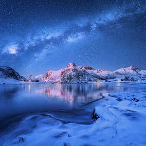 挪威洛福腾群岛的冬天,冰封的海岸上的银河雪覆盖着山脉北极景观蓝色的星空,水,冰,雪岩,银河美丽的图片
