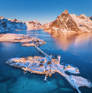 挪威洛福滕群岛海上雪山上的桥梁鸟瞰图冬天日出时雷恩哈莫伊景观蓝色的水,岩石,建筑物,买车,道路,桥梁的风景图片