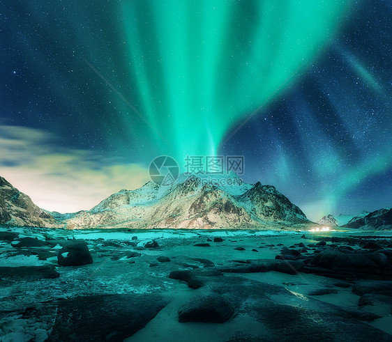 雪山上的极光,沙滩上石头挪威洛福滕岛的北极光极地灯光的星空夜间冬季景观与绿色北极光,岩石,照明图片