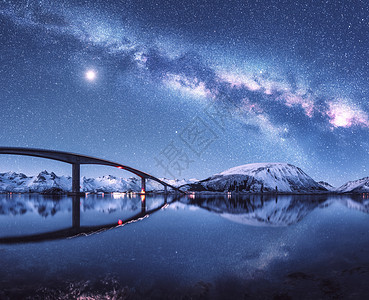 桥星空与银河雪覆盖的山脉反射水中夜间景观与道路,雪岩,天空与月亮,银河,星星,海洋挪威洛福滕岛的冬天图片