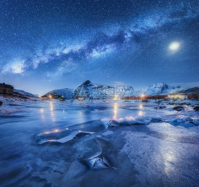 冰冻的海岸之上的银河,雪覆盖着山脉星空,挪威的夜晚,月亮冬天星系冰雪岩建筑照明银河的景观图片