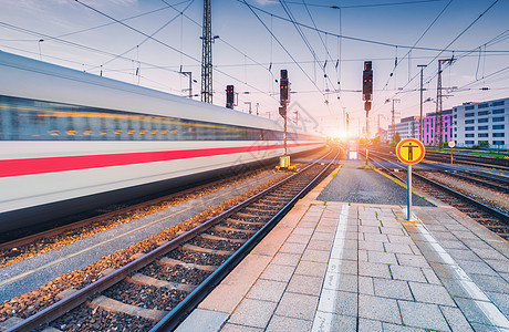 日落时火车站上运动的高速列车欧洲的铁路站台上移动模糊的现代城际列车客运铁路运输晚上的铁路旅行图片