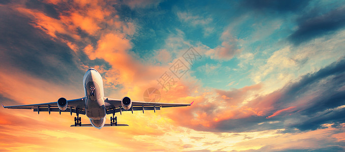 日落时降落五颜六色的天空上的飞机飞机的景观蓝天上飞行,橙色红色的云乘坐客机的旅行背景商业飞机私人飞机图片