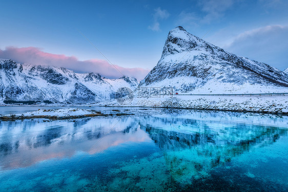 美丽的雪覆盖着群山蓝天,黄昏时云层反射水中冬季景观大海,雪岩,蓝天,倒影,日落洛芬岛,挪威黄昏图片