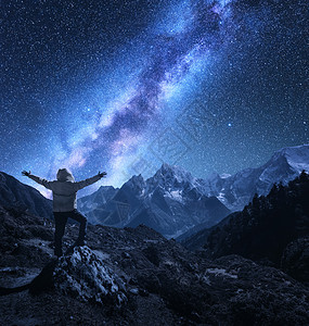 个站立的人的轮廓,举手臂石头,山脉星空与银河夜间尼泊尔明亮的星星旅行山岭星系的景观图片