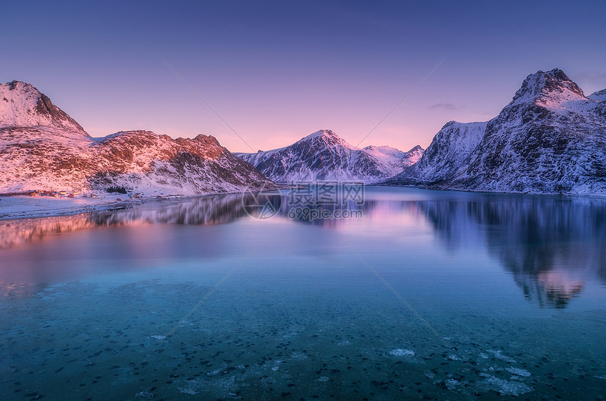 黄昏时,雪覆盖的山脉五颜六色的天空反射水中冬天的景观大海,雪岩,紫色的天空,日落时的倒影洛芬岛,挪威黄昏自然图片