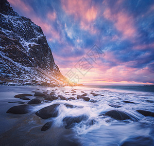 沙滩上模糊的水中的石头,蓝天上五颜六色的云,日落时雪山犹他州海滩,洛芬岛,挪威冬季景观与海洋,波浪,岩石晚上图片