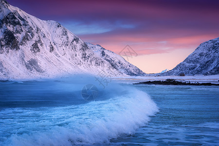 挪威洛福腾群岛的沙滩上,冬天蓝色的大海波浪风景雪山,五彩缤纷的天空粉红色紫色的云,绿松石的水挪威海滨图片