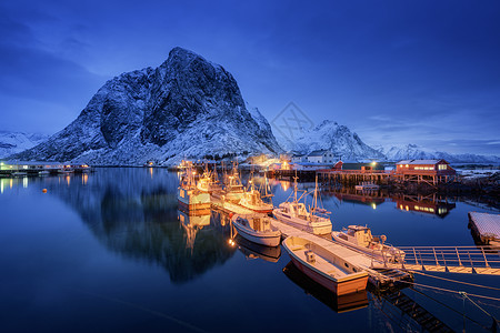 晚上船的渔村,洛芬岛,挪威冬天的风景房子,码头,照明,雪山,大海,蓝色多云的天空黄昏时反射水中挪威罗布尔图片