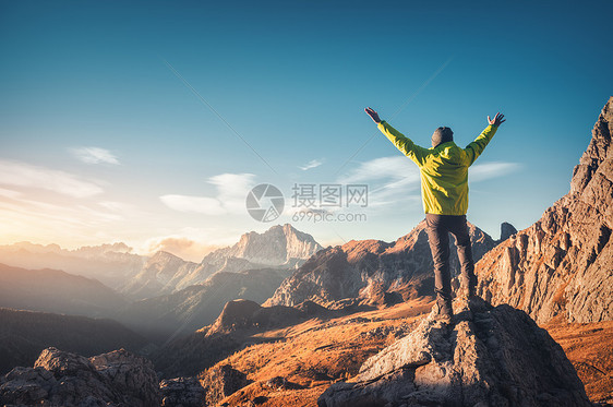 运动的人站石头上,举手臂日落时抗山谷快乐的轻人,岩石,秋天的森林蓝天白云石,意大利旅行者高山上徒步旅行图片