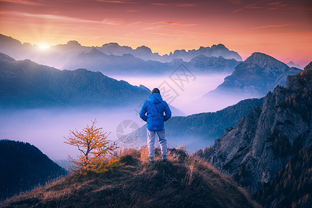 山顶上的人白云岩的秋天,五颜六色的日落时,看着低云的山谷风景与旅行者,雾山,森林秋天,美丽的天空黄昏阿尔卑斯山背景图片