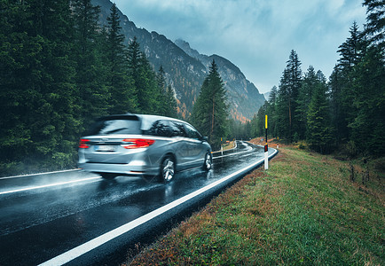 模糊的汽车秋天的森林里的道路上运动阴雨天完美的沥青山路巷道,意大利阿尔卑斯山的松树运输雾林中的公路旅行图片