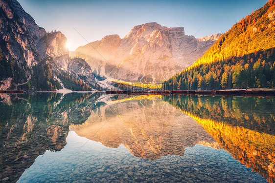 美丽的布莱斯湖秋季日出白云岩,意大利风景与山,金色的阳光,水与倒影,树木与橙色的叶子秋天的早晨意大利阿尔卑斯山旅图片