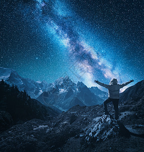 个站立的人的轮廓,举手臂石头,山脉星空与银河夜间尼泊尔明亮的星星旅行山岭星系的景观图片