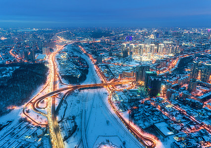 冬季寒冷夜晚美丽的现代城市的鸟瞰图道路建筑物雪街道上的交通景观天际线远离无人机的城市景观市中心高速公路的鸟瞰图片