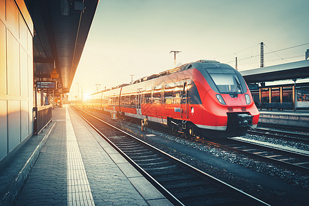 美丽的火车站与现代高速红色通勤列车五颜六色的日落带复古色调的铁路火车铁路站台工业铁路旅游图片