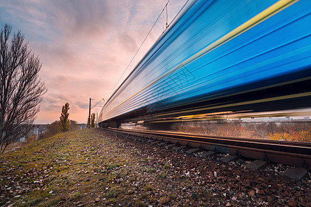 高速蓝色客运列车铁路轨道上运动日落模糊的通勤列车天空多云的火车站铁路旅游,铁路旅游黄昏时的工业景观图片