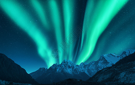 北极光覆盖了欧洲的山脉冬天的北极光夜间景观与绿色极地灯雪山星空极光自然背景图片