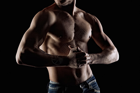 肌肉发达的男人穿着黑色专注双手背景图片